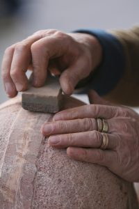 Hands carving wood